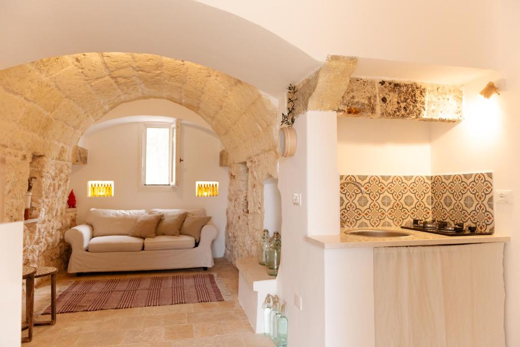- un salon avec un canapé et une voûte dans l'établissement Tenuta Lavati, Santa Maria di Leuca, à Castrignano del Capo