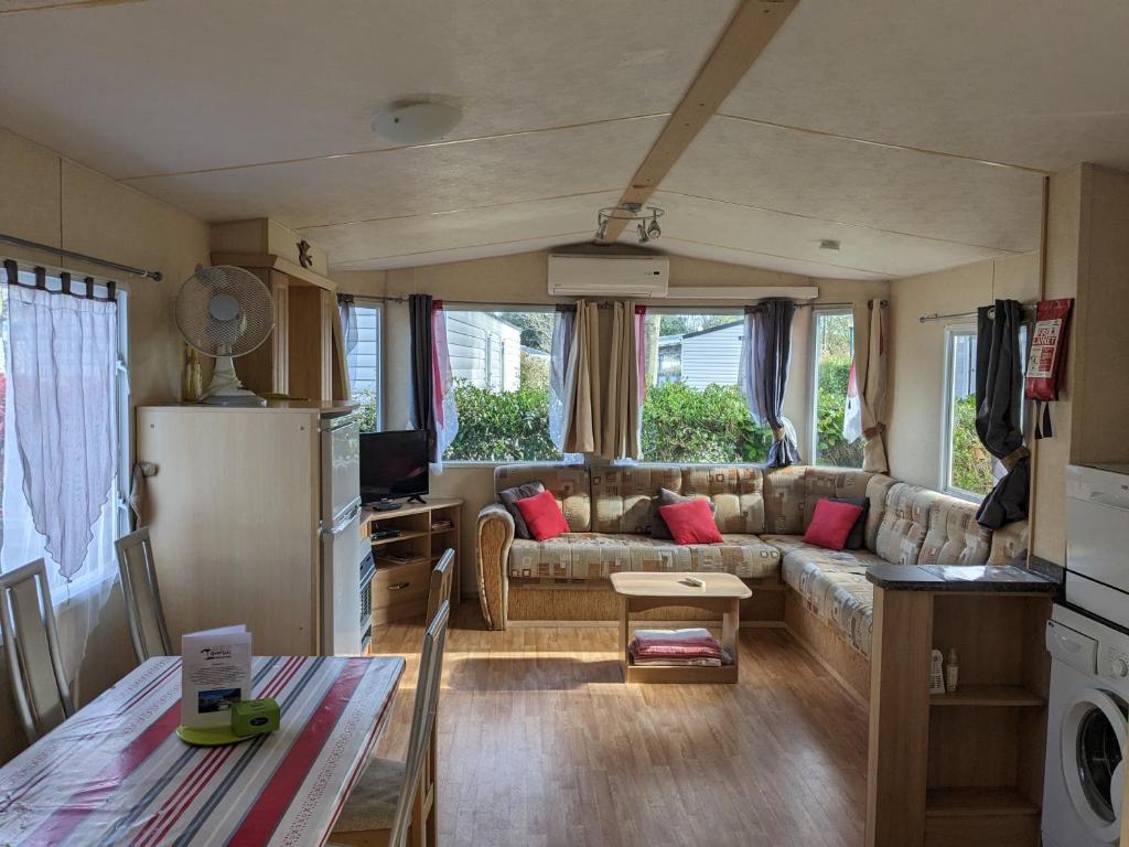un salon avec un canapé et une table dans l'établissement MOBIL HOME SPACIEUX 608 village SIBLU LA RESERVE, à Gastes