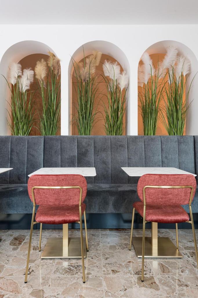 2 tables et 2 chaises dans une pièce ornée de plantes dans l'établissement Hotel Marco Polo 3 Stelle Superior, à Lido di Jesolo