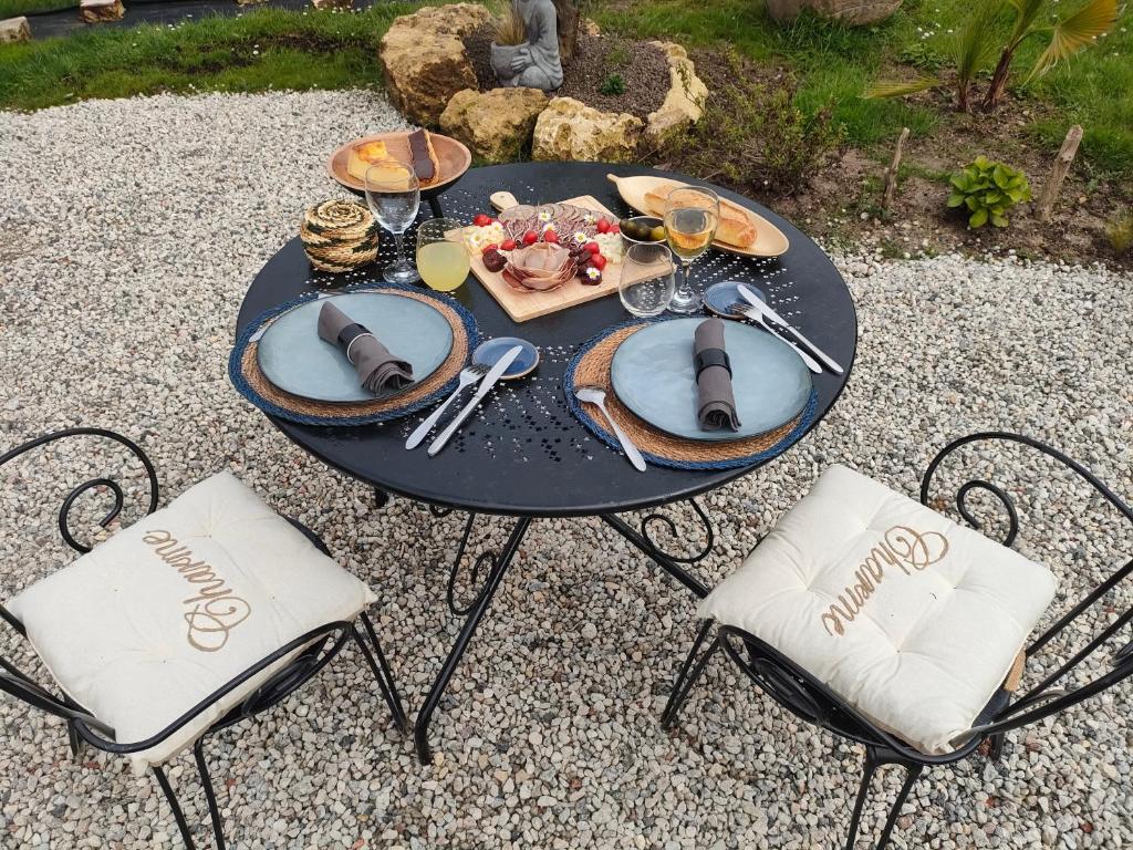 - une table noire avec des verres de vin et de la nourriture dans l'établissement La roulotte D'elfes, à Thénac