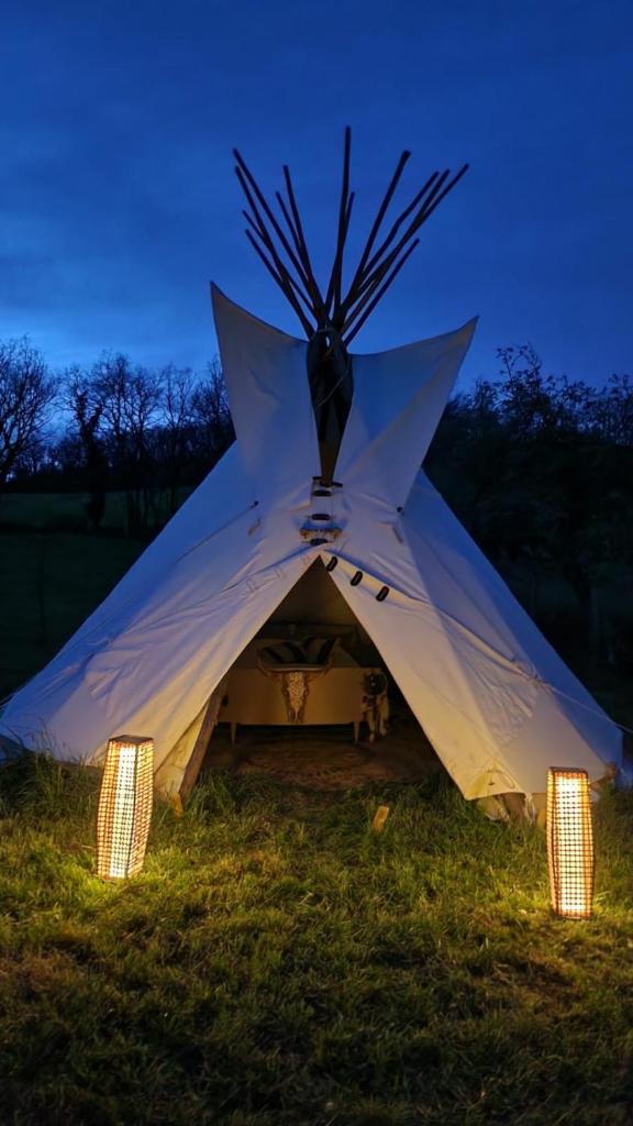 une tente blanche avec des lumières sur l'herbe dans l'établissement Tipi des amoureux, à Moulayrès