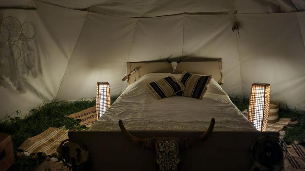une chambre avec un lit dans une tente dans l'établissement Tipi des amoureux, à Moulayrès