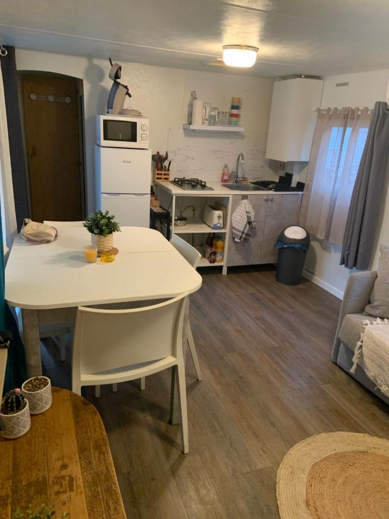 une cuisine et un salon avec une table et des chaises blanches dans l'établissement Camping pedro, au Grau-dʼAgde