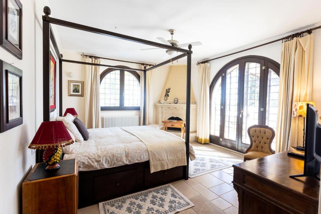 une chambre avec un lit, un bureau et une télévision dans l'établissement Torre Guaceto Luxury Masseria with Salted Pool, à Serranova 87 autres photos