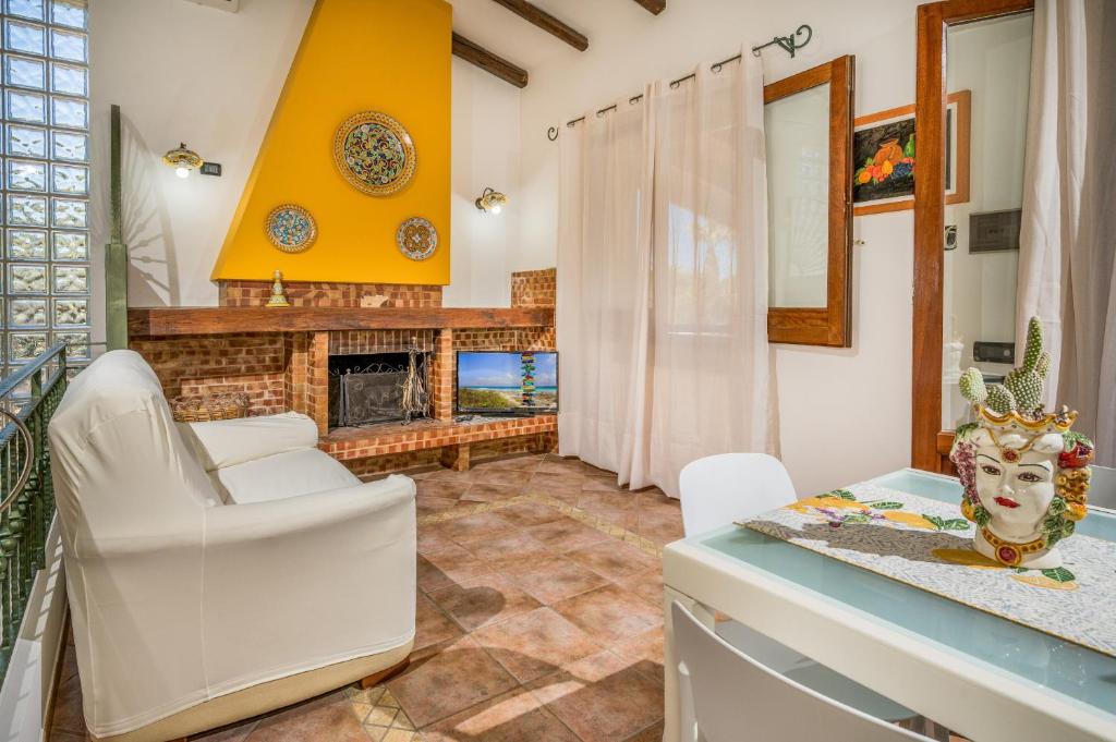 - un salon avec des chaises blanches et une cheminée dans l'établissement Villa Miceli con piscina privata, à Scopello
