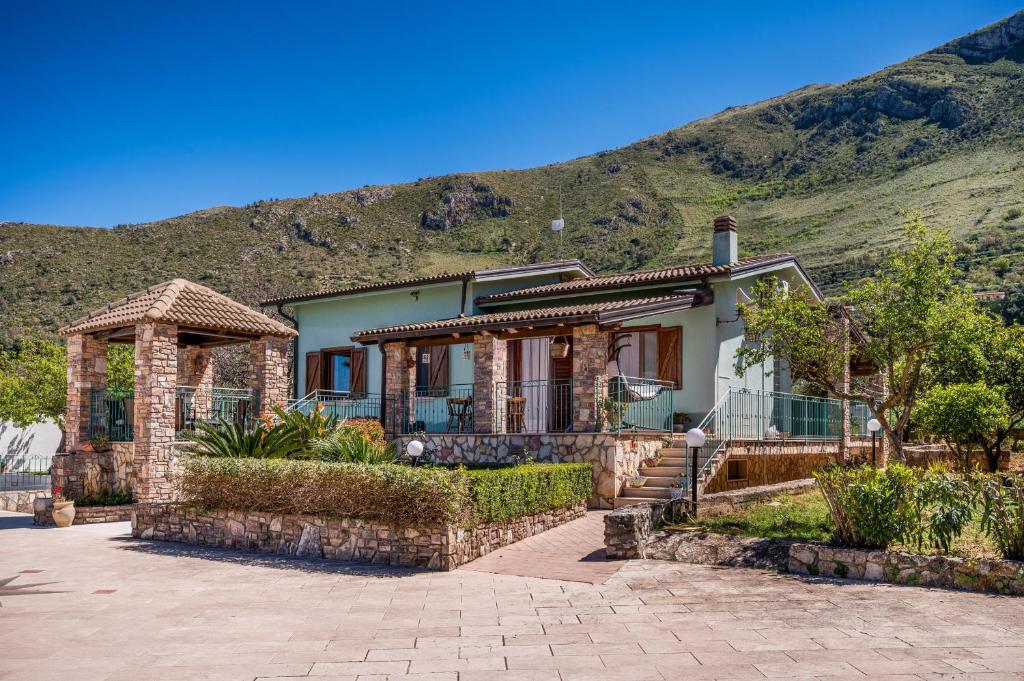 une maison avec une montagne en arrière-plan dans l'établissement Villa Miceli con piscina privata, à Scopello