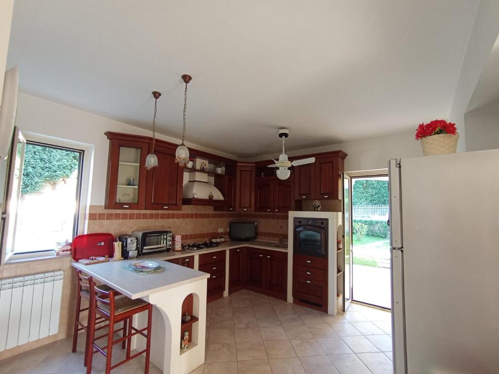 une cuisine avec des armoires en bois et un réfrigérateur blanc dans l'établissement Villa Framaca, à Furnari