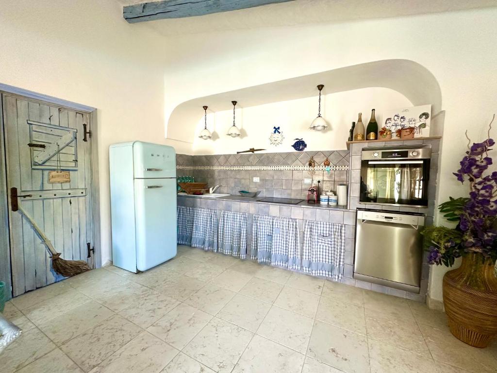 La cuisine est équipée d'un réfrigérateur et d'un évier. dans l'établissement Villa del Sole, piscina privata, spiaggia a 400 mt, à San Teodoro