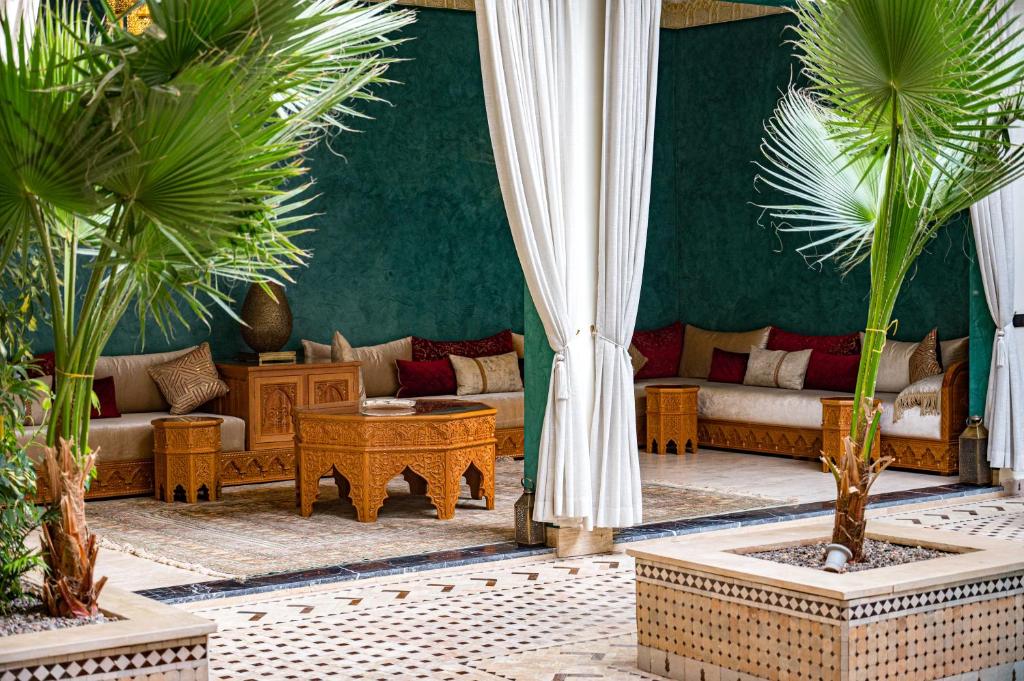 - un salon avec des canapés et des palmiers dans l'établissement Riad Tonaroz, à Marrakech