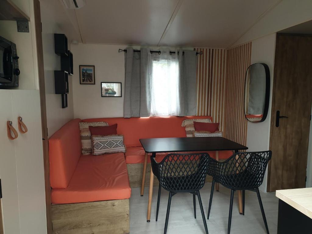 un salon avec un canapé, une table et des chaises dans l'établissement Camping Domaine des Iscles, à La Roque-dʼAnthéron