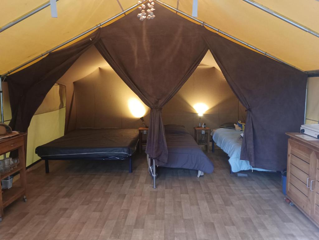 une chambre avec deux lits dans une tente dans l'établissement Tente safari au Pont du Gard, à Vers-Pont-du-Gard