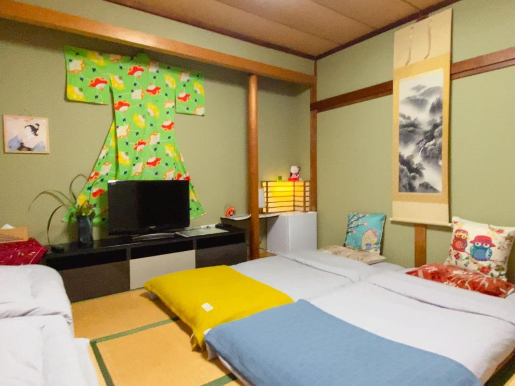 une chambre avec un lit et une télévision dans l'établissement Hanamizuki Onsen Resort, à Itō 85 autres photos