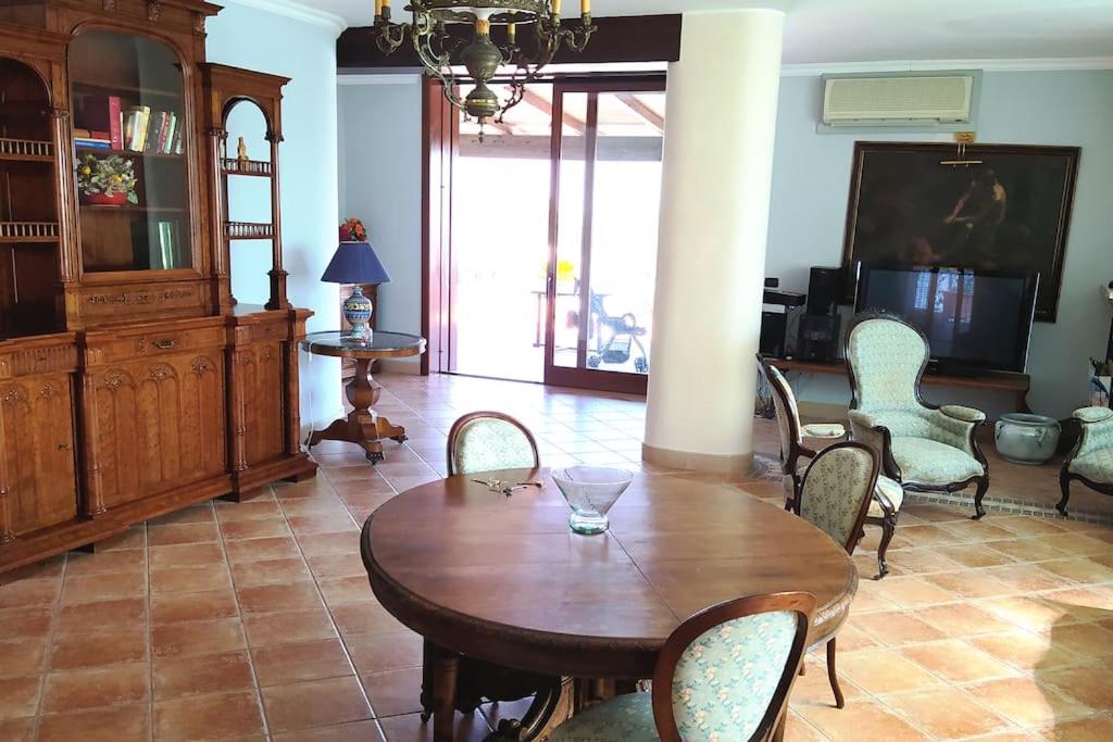 un salon avec une table et des chaises en bois dans l'établissement VILLA LIANA swimming pool, relax, countryside, à Trani