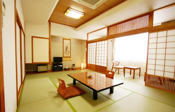 un salon avec une table et des chaises dans l'établissement Musashibou, à Hiraizumi