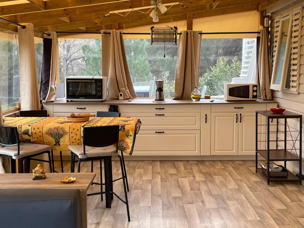 une cuisine avec des armoires blanches et une table et des chaises dans l'établissement Chez Dom et Sylvie, au Muy