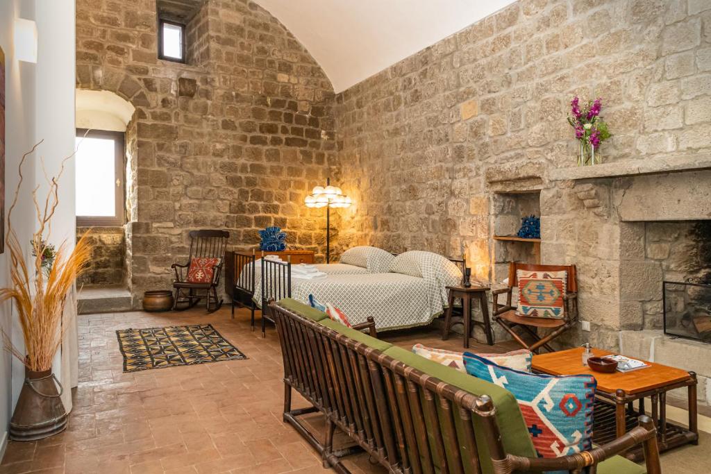 un salon avec un mur en pierre dans l'établissement Torre dei Belforti, à Montecatini Val di Cecina