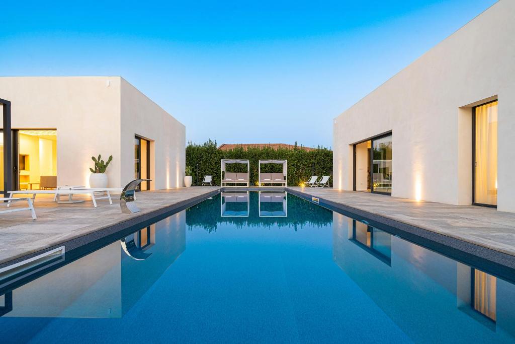 une piscine à côté d'une maison avec de l'eau bleue dans l'établissement Villa Bonita, à Syracuse