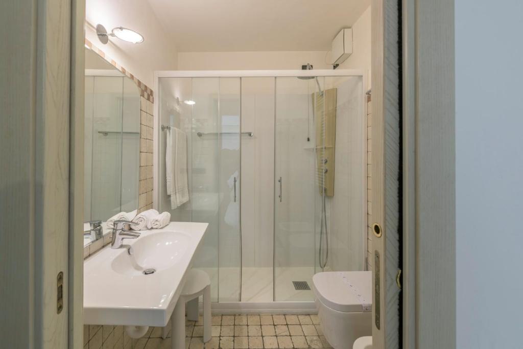 une salle de bain avec douche, lavabo et toilettes dans l'établissement Hotel Golf Inn, à Lignano Sabbiadoro 22 autres photos
