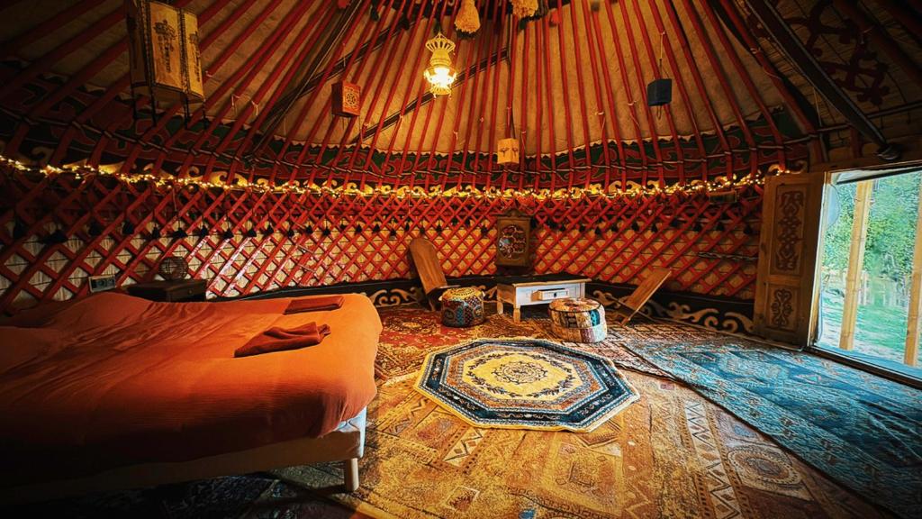 - une chambre avec un grand lit dans une yourte dans l'établissement La yourte kirghize, à Alès