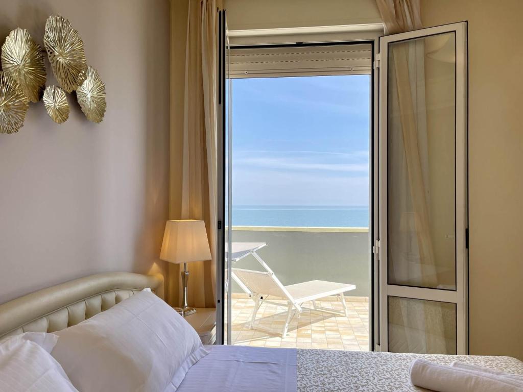 une chambre avec un lit et une vue sur l'océan dans l'établissement Brasil Seaview Hotel, à Milano Marittima