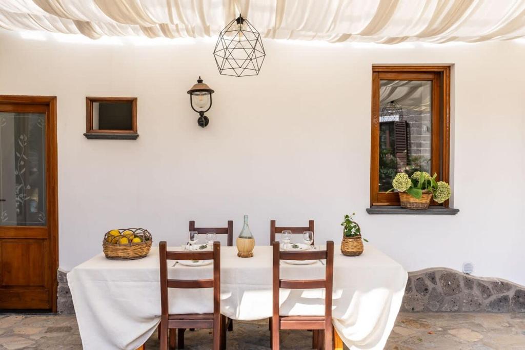 une salle à manger blanche avec une table et des chaises blanches dans l'établissement Villa Mimosa Rustic Elegance Views & Pool, à Massa Lubrense