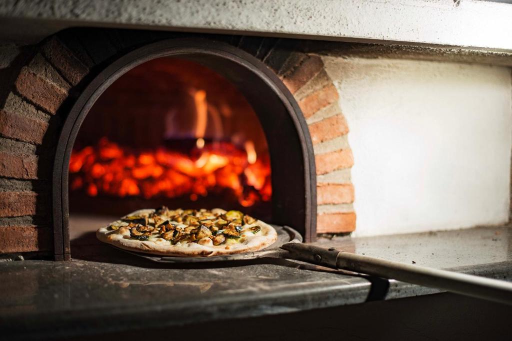 une pizza est cuite dans un four en briques dans l'établissement Villa Mimosa Rustic Elegance Views & Pool, à Massa Lubrense
