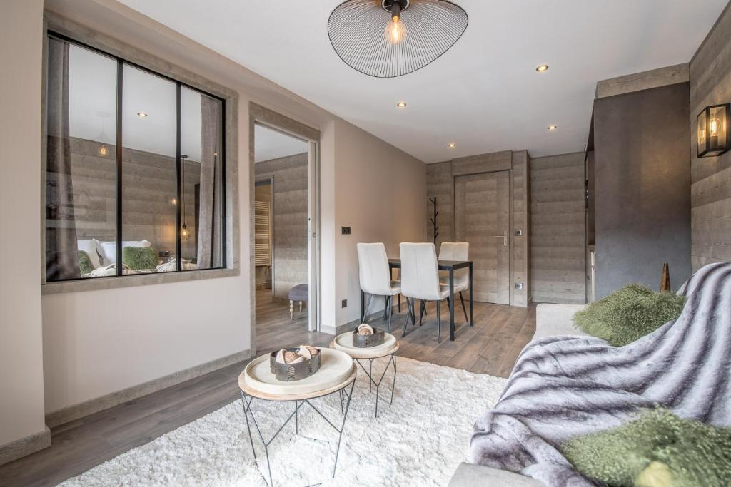 un salon avec un canapé et une table dans l'établissement Superbe Appartement au Plateau Rond-Point des Pistes Classé 3 Etoiles et Label Méribel, à Les Allues