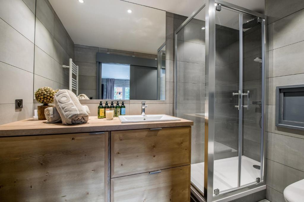 une salle de bain avec un lavabo et une douche dans l'établissement Superbe Appartement au Plateau Rond-Point des Pistes Classé 3 Etoiles et Label Méribel, à Les Allues 5 autres photos