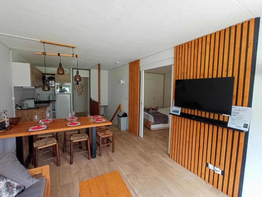 Il comprend un salon et une cuisine avec une table et une télévision. dans l'établissement Superbe 3 pieces vue panoramique pied des pistes, à La Mongie