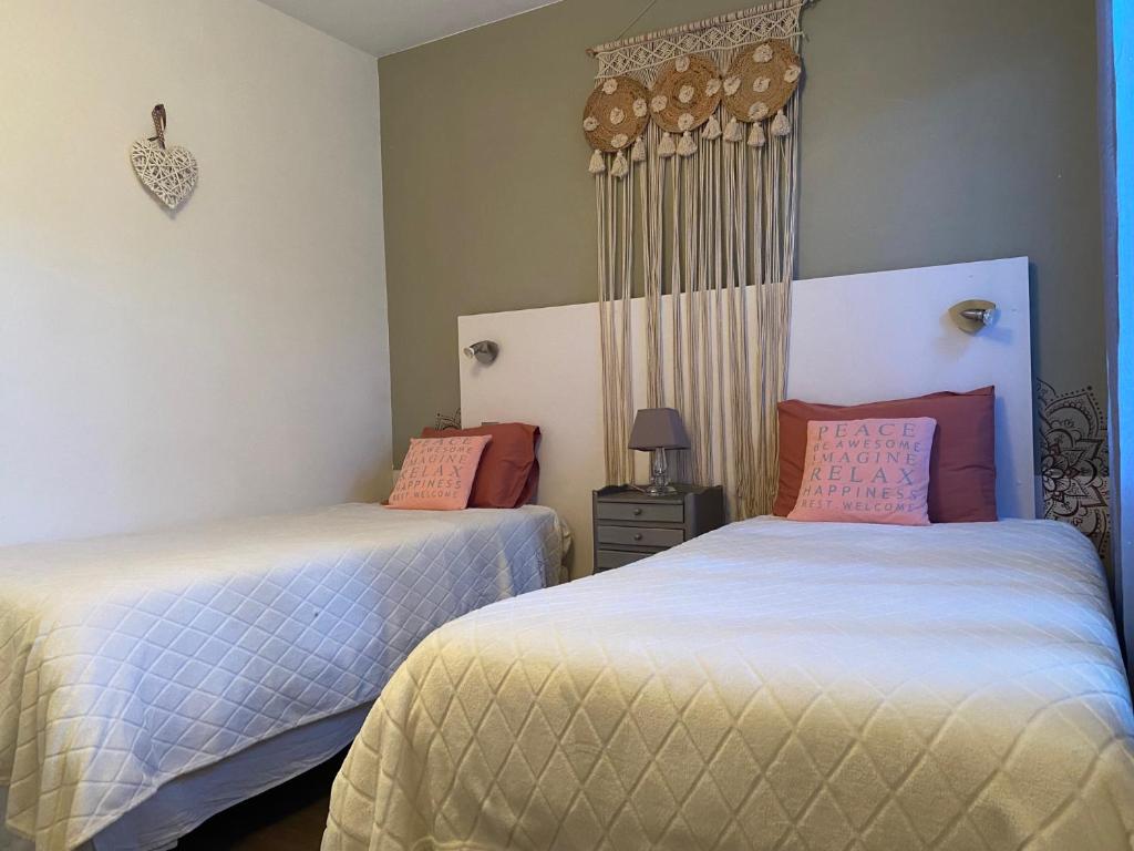 - une chambre avec 2 lits avec des oreillers blancs et roses dans l'établissement Gites d'Ici et d'Ailleurs 1 & 2 -famille ou groupe- Dépendances dans propriété proche Bordeaux et Bassin Arcachon, à Saint-Morillon 37 autres photos
