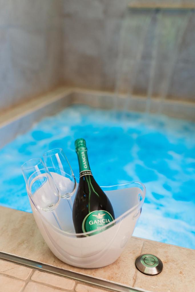 - une bouteille de vin dans un bol près de la piscine dans l'établissement LUXUITE Spa con Piscina o Jacuzzi, à Alberobello