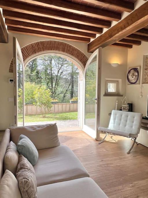 un salon avec un canapé et une grande fenêtre dans l'établissement Villino Mami con piscina e vista mare panoramica, à Mommio