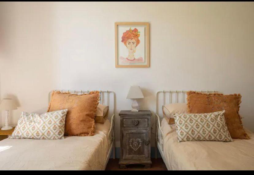 - une chambre avec 2 lits et une table avec une photo dans l'établissement VILLA AZUL, à Castellammare del Golfo