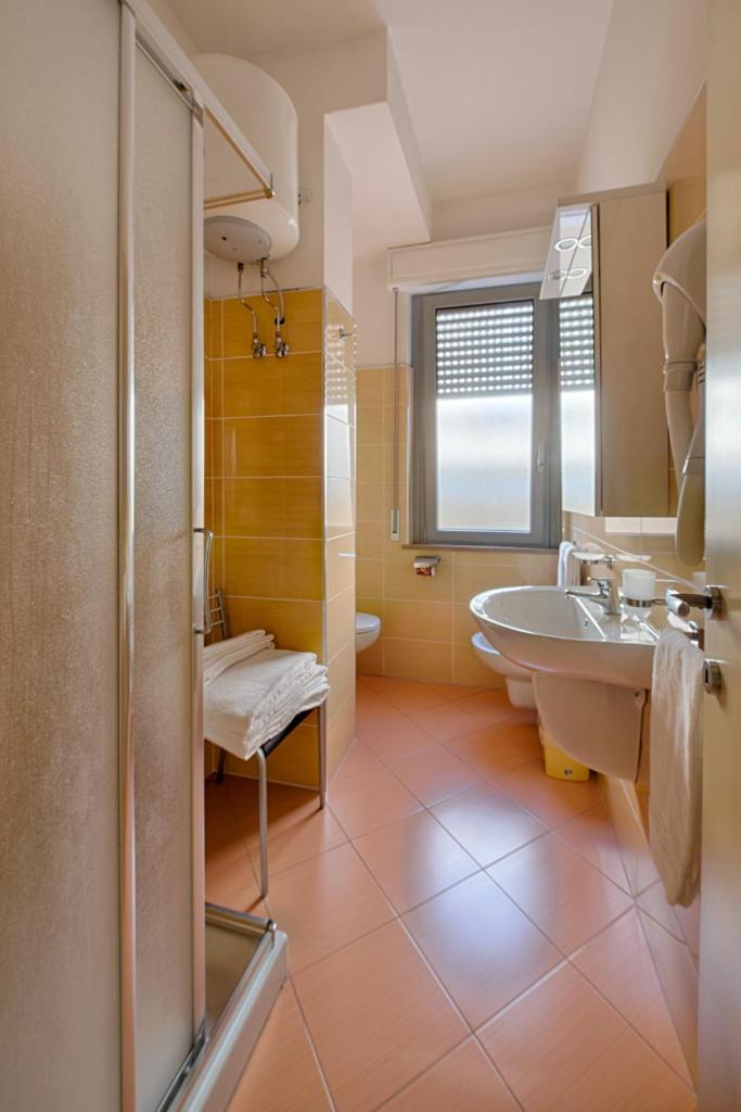 une salle de bain avec un lavabo, des toilettes et un miroir dans l'établissement Residence Palazzo Gasparroni, à Tortoreto Lido 38 autres photos