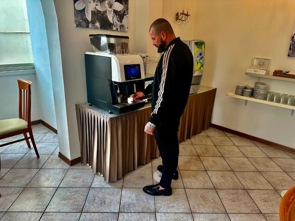 un homme en costume debout à un comptoir dans l'établissement Hotel Napoleon, à Riccione