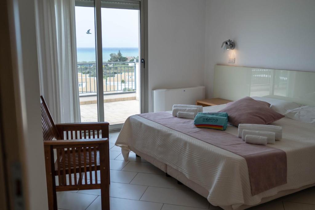 une chambre avec un lit avec vue sur l'océan dans l'établissement Sikelika Residence Sul Mare, à Scoglitti
