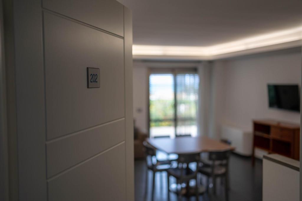 - un couloir avec une table et des chaises dans la chambre dans l'établissement Sikelika Residence Sul Mare, à Scoglitti