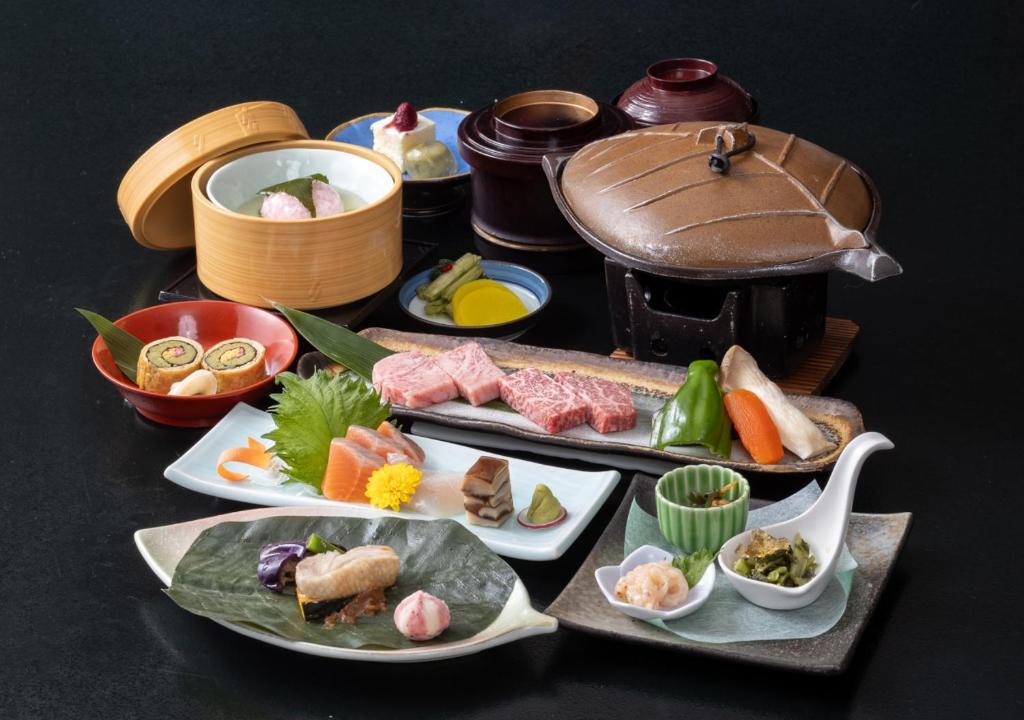 une table avec plusieurs assiettes de nourriture dessus dans l'établissement Morino Hotel, à Kiso