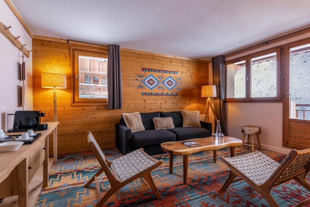 un salon avec un canapé et une table dans l'établissement Chalet Hotel Kaya, aux Menuires