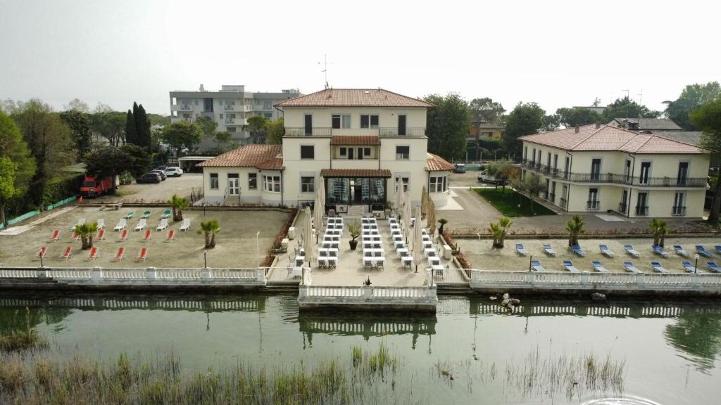 une grande maison avec un quai dans l'eau dans l'établissement Hotel Villa Trieste, à Sirmione