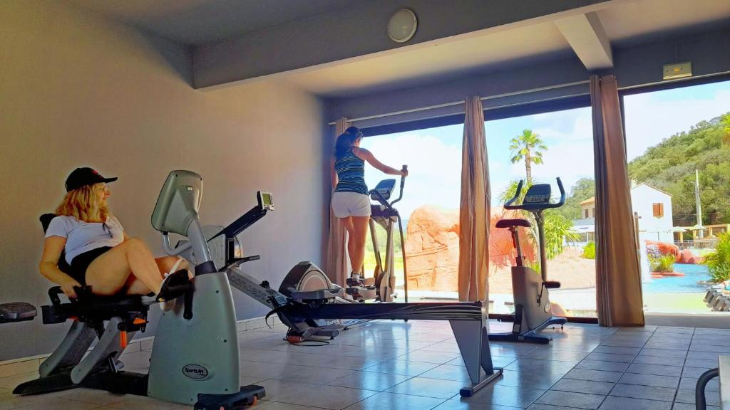 une femme faisant de l'exercice dans une salle de sport avec un homme debout à la fenêtre dans l'établissement Camping Vallée du Paradis, à Agay 37 autres photos