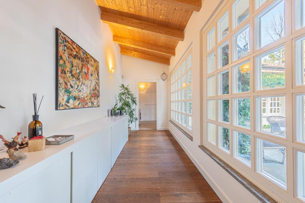- un couloir avec de grandes fenêtres et des plafonds en bois dans l'établissement Casa Rita, Charming House with pool, Asti, à Asti