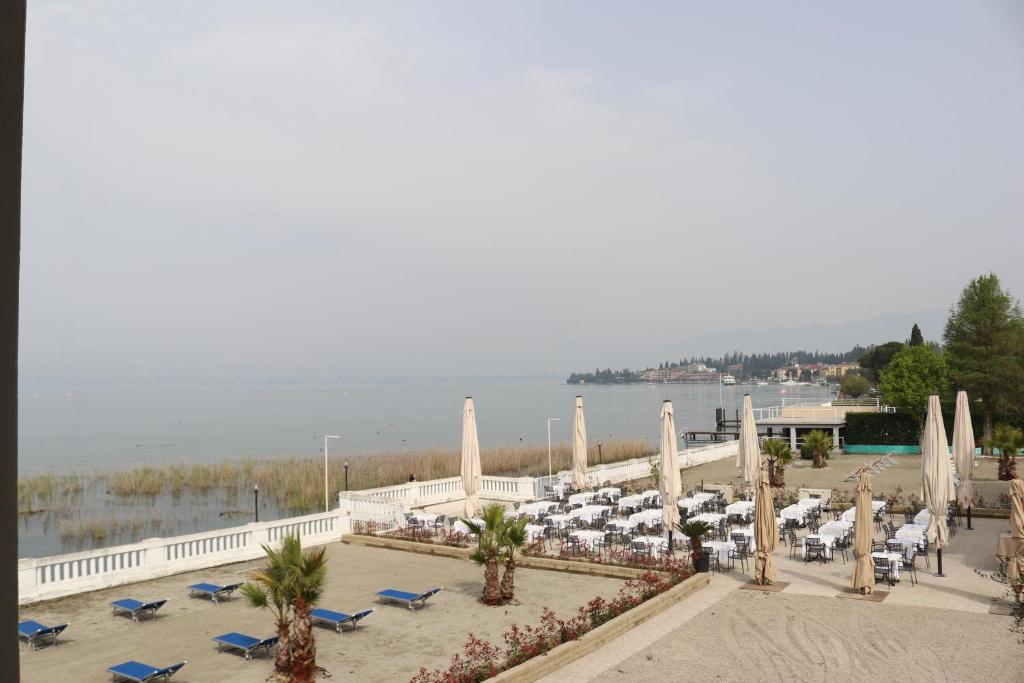 - une vue sur une plage dotée de chaises et de parasols dans l'établissement Hotel Villa Trieste, à Sirmione 24 autres photos