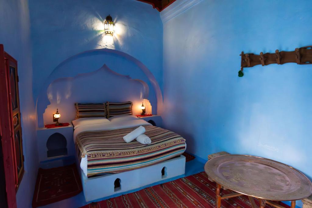 une chambre avec un lit dans une pièce bleue dans l'établissement Dar Dadicilef, à Chefchaouen