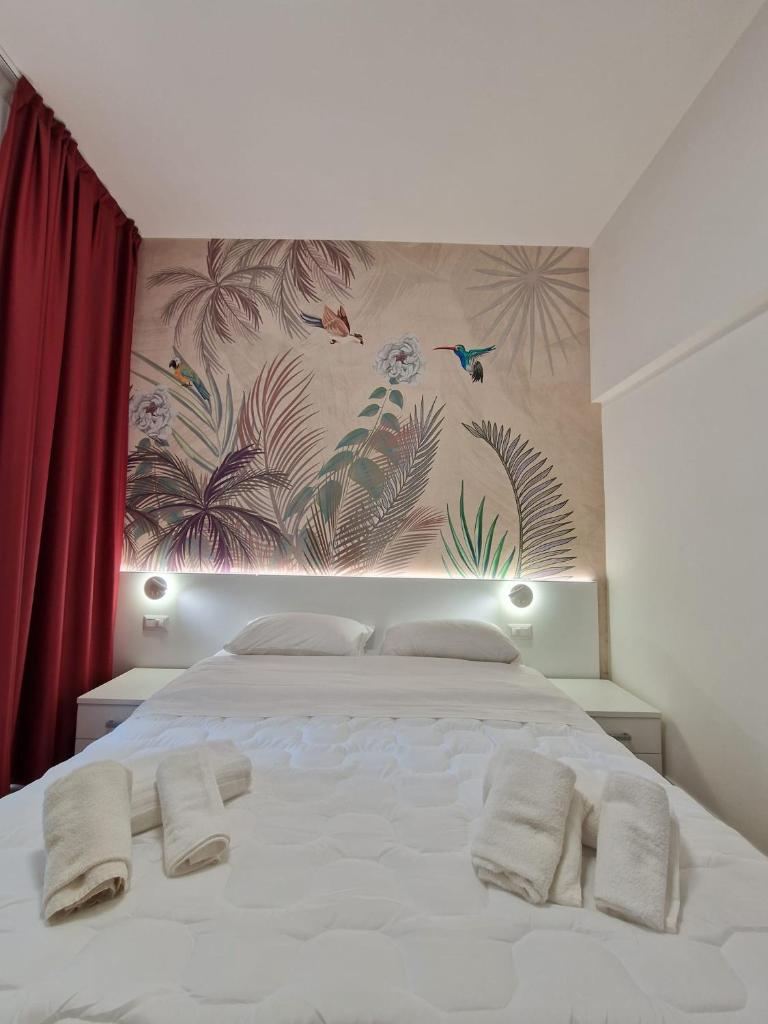 une chambre avec un lit blanc avec deux serviettes dessus dans l'établissement Hotel Ragno D'Oro, à Sottomarina