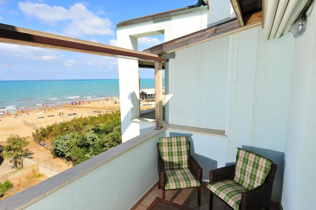 d'un balcon avec deux chaises et une vue sur la plage. dans l'établissement Hotel Aurora, à San Vincenzo
