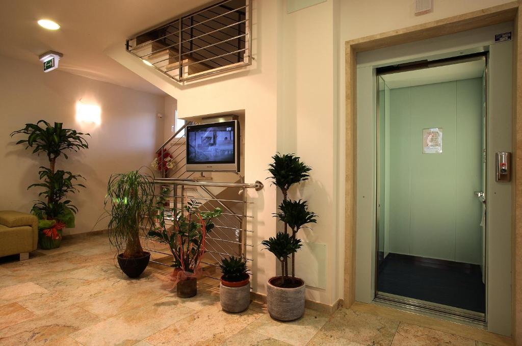 une chambre avec des plantes en pot et une porte avec une télévision dans l'établissement Hotel Aurora, à San Vincenzo