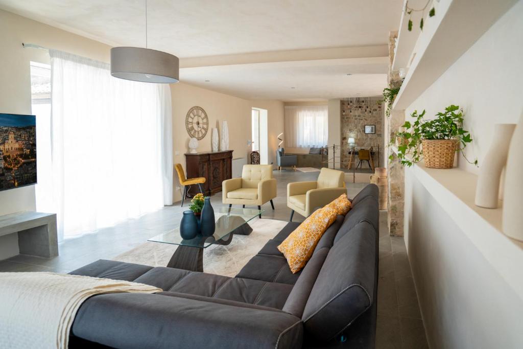 un salon avec un grand canapé et un salon avec dans l'établissement Villa Domus Sicilia - Charming Living, à Modica