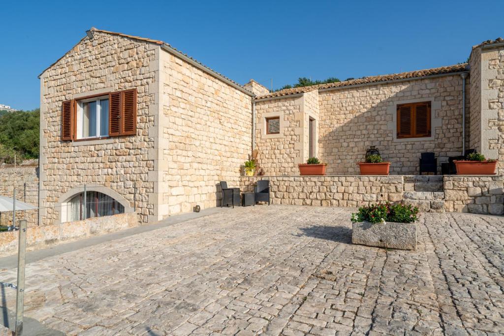 un bâtiment en pierre avec une allée en pierre dans l'établissement Villa Domus Sicilia - Charming Living, à Modica