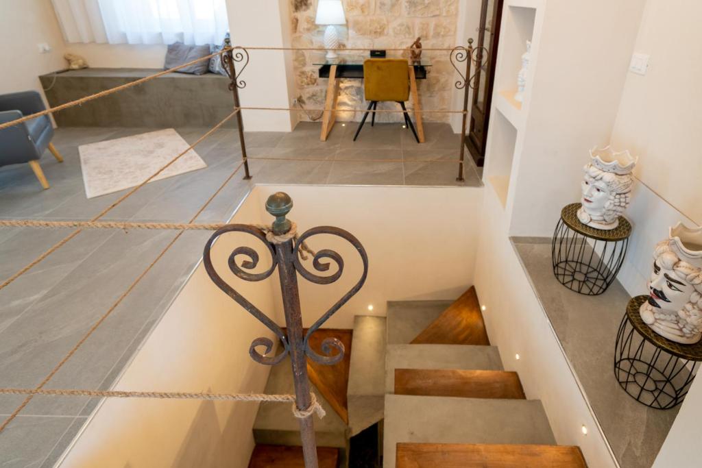 Un escalier mène à une chambre avec une table. dans l'établissement Villa Domus Sicilia - Charming Living, à Modica